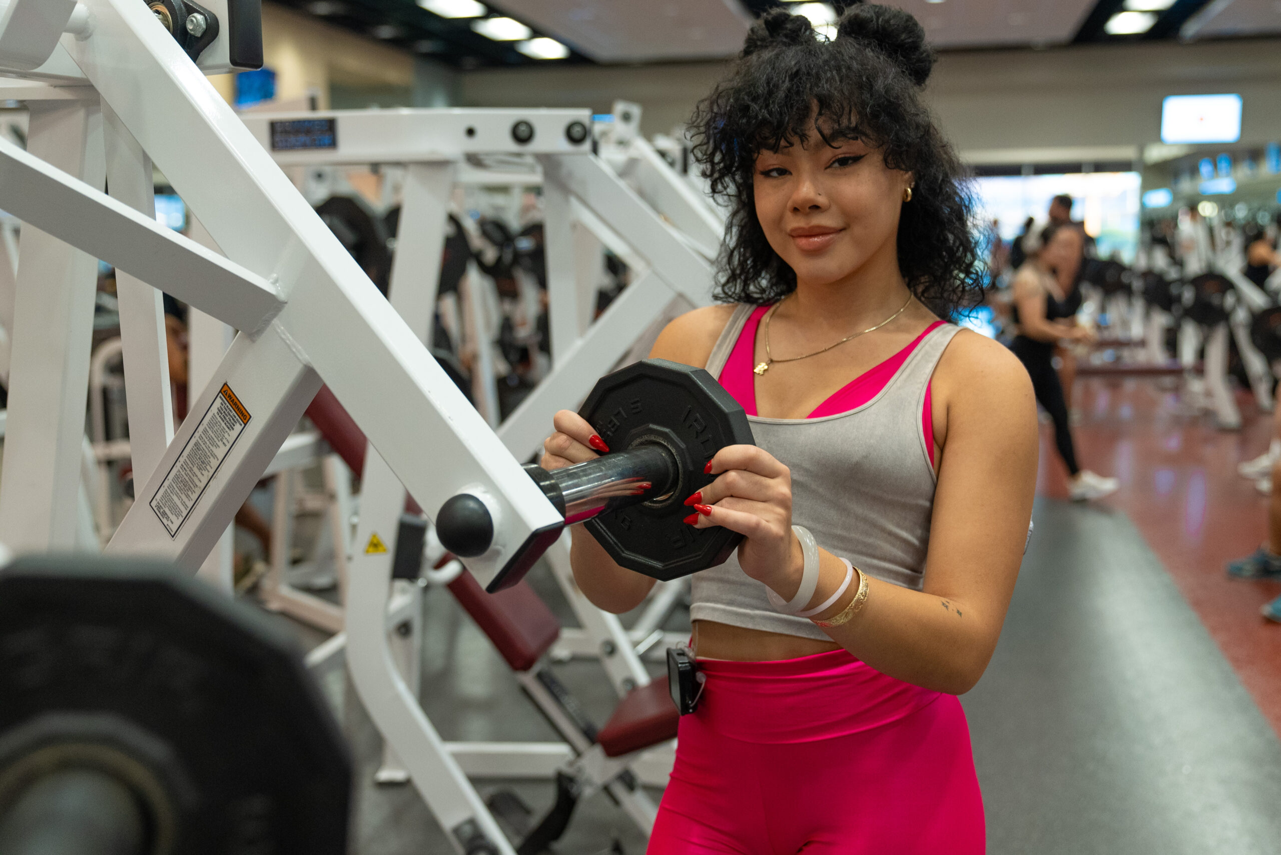 Girl putting weights on her workout machine for her brat summer.