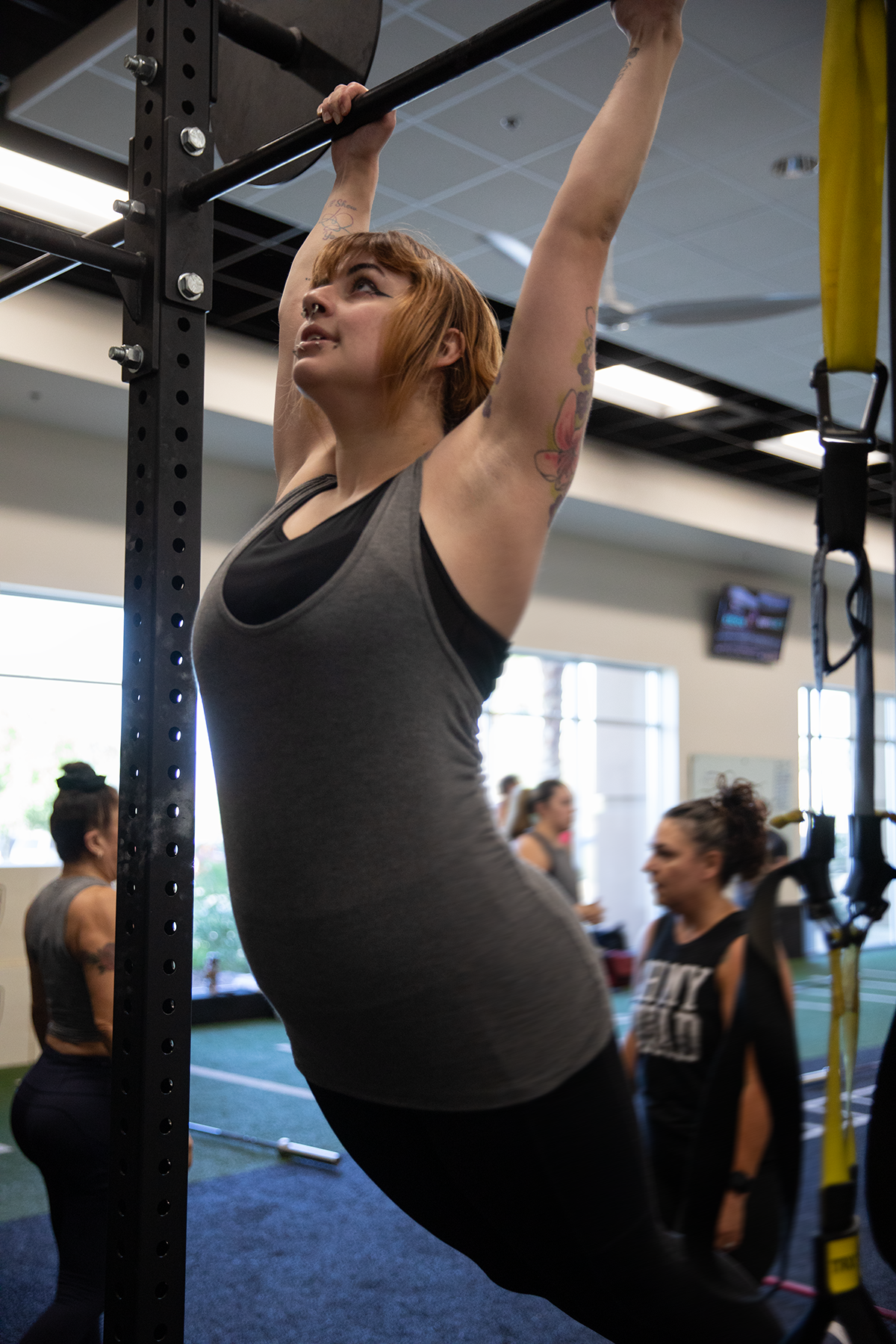 An athletic person does a kipling on a Crossfit rig.